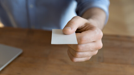 Businessman give business card with personal info to client or partner, close up. Worker holds calling-card with empty blank white mock up, share contact information for future collaboration concept