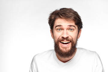 cheerful emotional bearded man gesturing with his hands close-up light background