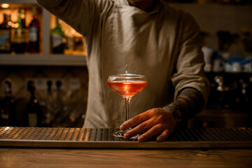 view on wine glass with splashes of bright cocktail which stands on the bar counter.