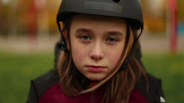 Closeup portrait of sad girl in rollerblade or skate helmet