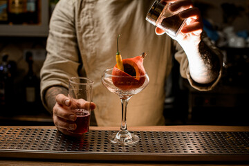 wine glass with small pumpkin and pepper inside it stands on the bar counter