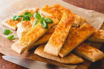 Homemade flat bread with cheese and basil closeup on wooden background
