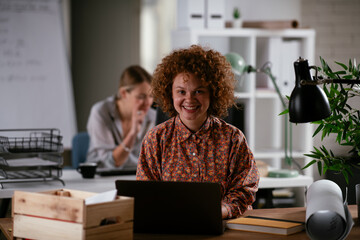 Happy businesswoman working on laptop.