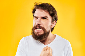 Fototapeta premium emotional bearded man gesturing with hands aggression discontent close-up yellow background