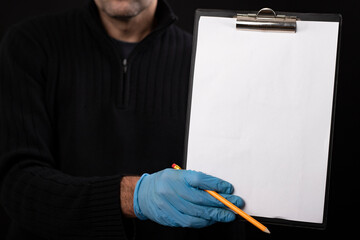 A blank sheet of paper and a pencil held by a courier. Delivery of goods ordered with home delivery.