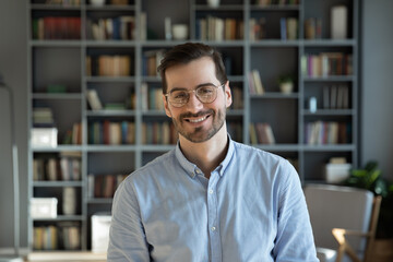 Head shot handsome millennial 30s professional employee worker posing for camera at modern office....