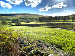 Rural Yorkshire Dales landscape, with fields, a stream, and hills in the far distance at, Halton Gill, Skipton, UK