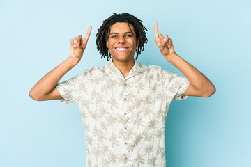 Young african american rasta man indicates with both fore fingers up showing a blank space.