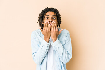 Young african american rasta man shocked, covering mouth with hands, anxious to discover something...