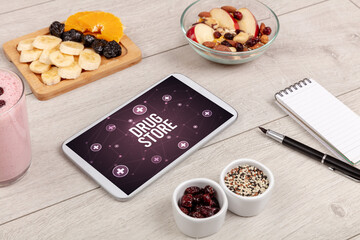 DRUG STORE concept in tablet pc with healthy food around, top view