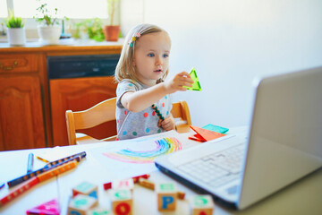 Toddler girl learning shapes in front of laptop