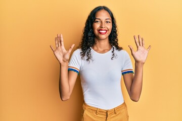 Young african american girl wearing casual clothes showing and pointing up with fingers number ten while smiling confident and happy.