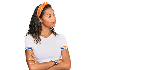 Young african american girl wearing casual clothes looking to the side with arms crossed convinced and confident