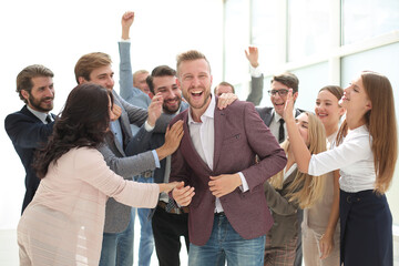 happy team of employees congratulating their colleague.