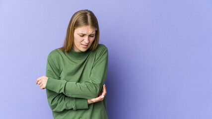 Young blonde woman isolated on purple background massaging elbow, suffering after a bad movement.