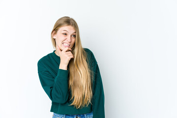 Young blonde woman isolated on white background touching back of head, thinking and making a choice.