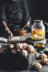 Woman cooks in a vintage kitchen on wooden tablet. Healthy drink, Eco, vegan.