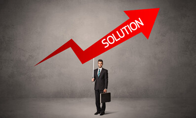 Fototapeta premium Young business person in casual holding road sign with SOLUTION inscription, business direction concept