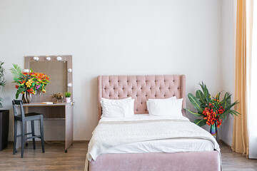 Contemporary ordinary design of spacious studio in soft warm colors. Simple furniture. Light large room with sunlight. Daytime. Tiled brown floor and white walls .