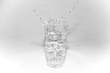 water splashes in a glass with ice on a white background