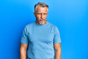 Middle age grey-haired man wearing casual clothes skeptic and nervous, frowning upset because of...
