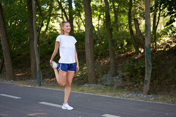 Woman runner stretching legs before exercising summer park  morning