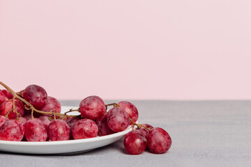Close-up of a bunch of grapes on a pink background