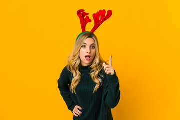 Young blonde caucasian woman wearing reindeer horns having an idea, inspiration concept.