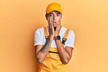 Young handsome african american man wearing handyman uniform over yellow background tired hands covering face, depression and sadness, upset and irritated for problem