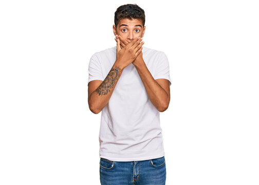 Young handsome african american man wearing casual white tshirt shocked covering mouth with hands for mistake. secret concept.
