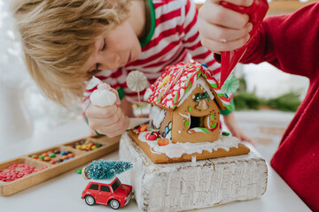 Children decorated Christmas gingerbread house on the table