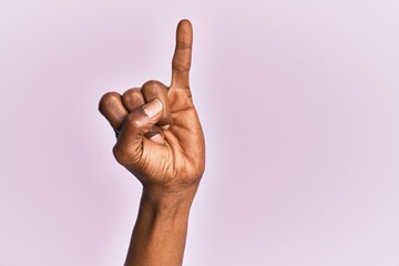 Arm and hand of black middle age woman over pink isolated background showing little finger as pinky...
