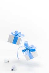 Obraz na płótnie Canvas Holiday winter blue. White gift box with blue ribbon, New Year balls in Christmas composition on white background for greeting card. Copy space. Winter holidays, New Year.