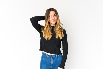 Young caucasian woman isolated on white background touching back of head, thinking and making a choice.