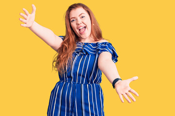 Young beautiful redhead woman wearing casual clothes looking at the camera smiling with open arms for hug. cheerful expression embracing happiness.