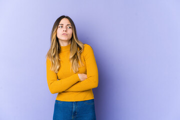 Young caucasian woman isolated on purple background tired of a repetitive task.