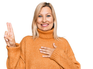 Middle age caucasian woman wearing casual winter sweater smiling swearing with hand on chest and fingers up, making a loyalty promise oath
