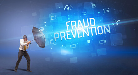 Businessman defending with umbrella from cyber attack and FRAUD PREVENTION inscription, online security concept