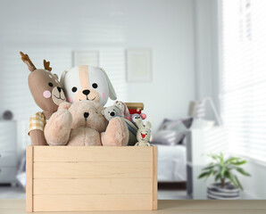 Set of different cute toys on wooden table in children's room. Space for text