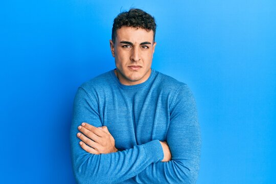 Handsome young man wearing casual clothes sleeping tired dreaming and posing with hands together while smiling with closed eyes.