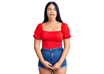 Young beautiful asian girl wearing casual clothes sticking tongue out happy with funny expression....