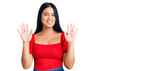 Obraz premium Young beautiful asian girl wearing casual clothes showing and pointing up with fingers number ten while smiling confident and happy.