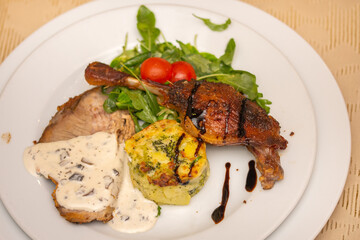 neck with mushroom sauce, duck confit, potatoes with broccoli and valerian with tomatoes