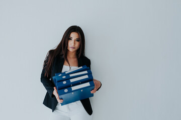 Beautiful brunette woman in business suit with paper folders in the office