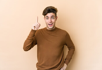 Young caucasian man isolated on beige background having an idea, inspiration concept.