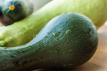 Still life - fresh whole zucchini, eggplant and parsley on a wooden board, close up