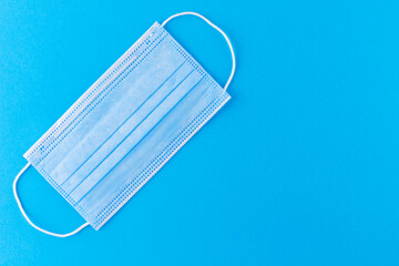 Face protective mask on a blue background. Disposable surgical face mask protective Coronovirus. Protection concept. Copy space