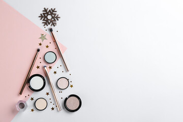 Christmas tree shape of decorative cosmetic products on color background, flat lay with space for...