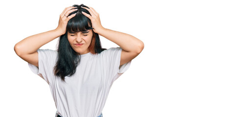 Young hispanic girl wearing casual clothes suffering from headache desperate and stressed because pain and migraine. hands on head.