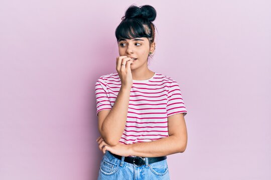 Young hispanic girl wearing casual clothes looking stressed and nervous with hands on mouth biting nails. anxiety problem.